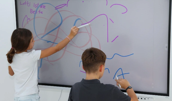 Kinder zeichnen gemeinsam auf einem Smartboard im ANKERZEIT-Freiraum