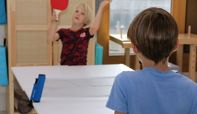 Kinder stehen am Tischtennistisch im ANKERZEIT-Freiraum