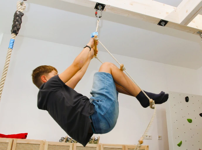 Kind hangelt an Seilen unter der Decke im ANKERZEIT-Freiraum