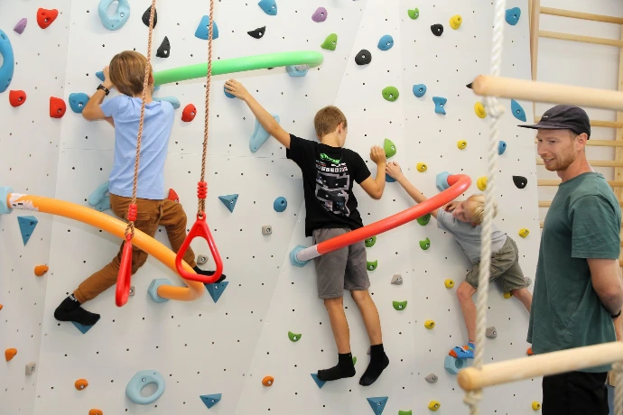 Kinder klettern und hangeln an der Boulderwand mit Poolnudeln im ANKERZEIT-Freiraum