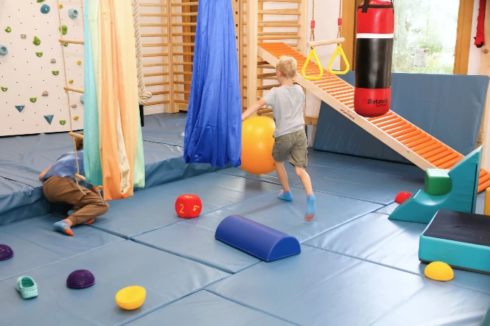 Kinder spielen mit Tüchern und Schaumstoffelementen im ANKERZEIT-Freiraum