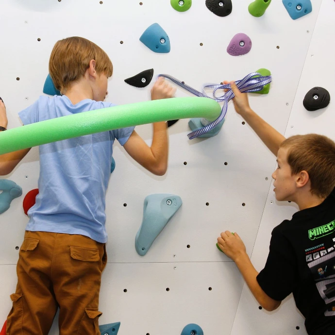 Kinder klettern an der Boulderwand im ANKERZEIT-Freiraum