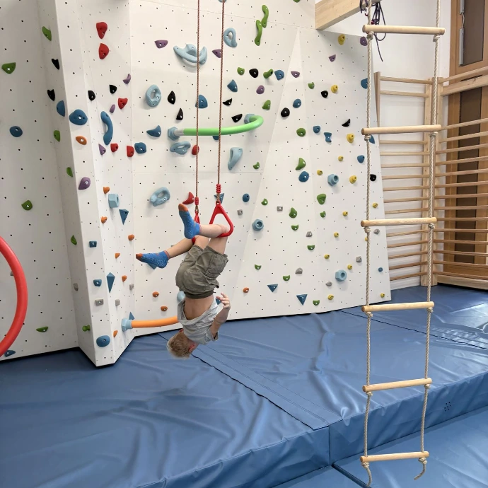 Kind klettert an der Boulderwand im ANKERZEIT-Freiraum